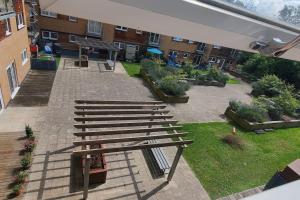 a group of wooden benches sitting in a courtyard at Luxurious and spacious 1 bd flat in Basildon