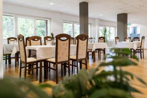 a dining room with white tables and chairs at Pension zum Hexenstieg in Schierke