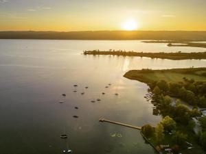 eine Luftansicht eines großen Wasserkörpers mit Booten in der Unterkunft Strandhotel SüdSee Diessen am Ammersee in Dießen am Ammersee