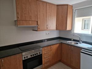 a kitchen with wooden cabinets and a sink at Apartamento vacacional in Torreblanca