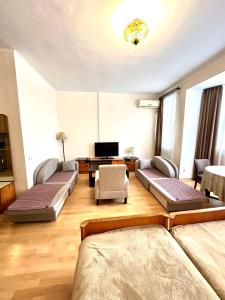 Una sala de estar con dos camas y un televisor. en Studio Flat in Center of Tbilisi, en Tiflis