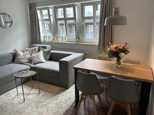 een woonkamer met een bank en een tafel bij Inselresidenz Strandburg - Ferienwohnung 106 in Juist