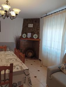 sala de estar con 2 mesas y chimenea en LA SOLANA, en Valdemoro-Sierra