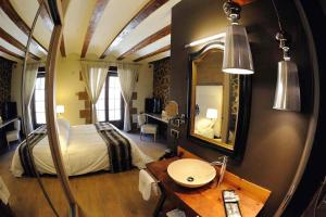 a bedroom with a bed and a desk and a mirror at La Posada de Mosqueruela in Mosqueruela