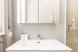 a white bathroom with a sink and a mirror at La bomboniera di Washington in Milan