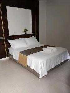a bedroom with a large bed with white sheets and pillows at Blue Haven Retreat in Thulusdhoo