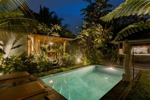 Moringa Ubud Villa في أوبود: وجود مسبح في الحديقة الخلفية للمنزل ليلا