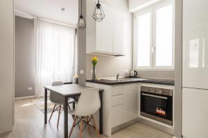 a kitchen with a table and a dining room at La bomboniera di Washington in Milan