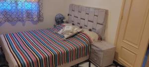 Dormitorio infantil con cama con manta a rayas en Villa, en Marrakech