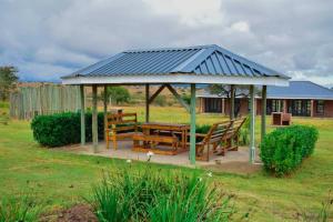 a gazebo with a table and benches in a yard at Uitval Lodge & Conference Centre 