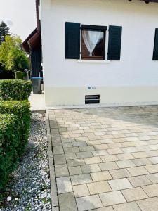 a house with a window and a stone driveway at kleine ein Zimmer Wohnung mit Gartenanlage in Salem