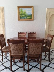 une table à manger et des chaises avec une photo sur le mur dans l'établissement Villa, à Marrakech