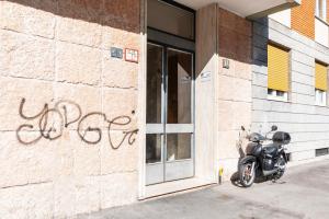 a motorcycle parked in front of a building with graffiti at La bomboniera di Washington in Milan