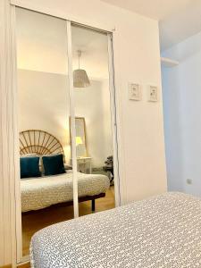 a mirror in a bedroom with a bed and a bed at Bright Apartment steps from Plaza de Toros and Wizink Center in Madrid
