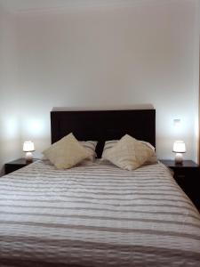 a bedroom with a large bed with two lamps at Portugal Home in Lagos