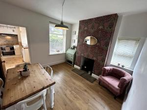 a living room with a table and a fireplace at Two Bed Charming Cottage in Crewe
