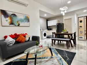 een woonkamer met een bank en een tafel bij 2BR Apartment @ Icon City in Petaling Jaya