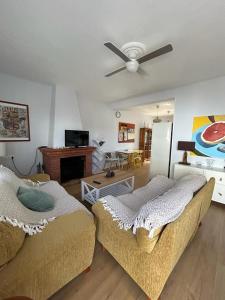 uma sala de estar com 2 camas e uma ventoinha de tecto em Casa de la Sierra em Arroyo de la Plata