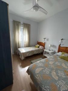 um quarto com 2 camas e uma ventoinha de tecto em Casa de la Sierra em Arroyo de la Plata