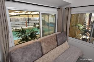 un divano in soggiorno con una grande finestra di Suites Luka a Had Nes