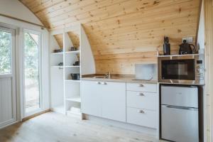 cocina con electrodomésticos blancos y techo de madera en Carlton Manor Pods, en Aldbrough