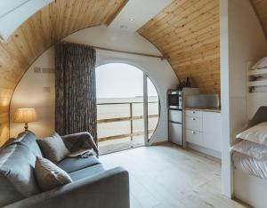 a living room with a couch and a view of the ocean at Carlton Manor Pods in Aldbrough