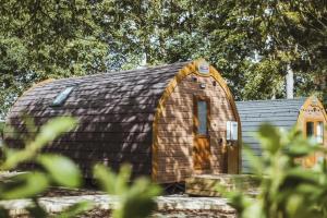 a small wooden building with a brown roof at Carlton Manor Pods in Aldbrough