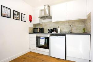 una cucina con armadi bianchi e lavandino di Central Buckingham Apartment #2 with Free Parking, Pool Table, Fast Wifi and Smart TV with Netflix by Yoko Property a Buckingham