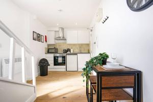 una cucina con armadi bianchi e tavolo in legno di Central Buckingham Apartment #2 with Free Parking, Pool Table, Fast Wifi and Smart TV with Netflix by Yoko Property a Buckingham