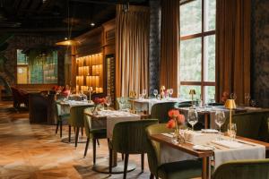 a dining room with tables and chairs and windows at Haffner Hotel & SPA Sopot in Sopot