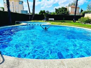 une personne dans un grand bassin d'eau bleue dans l'établissement Casa Brût - OLIVA NOVA, à Oliva