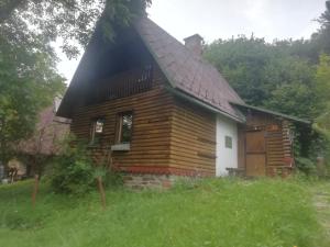 a log cabin with a black roof at Chata Lužná u Hanušovic 