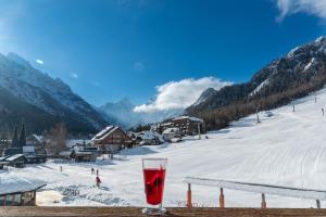 a glass of red wine sitting on a table in the snow at Ramada Resort Kranjska Gora in Kranjska Gora
