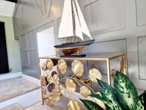 un barco modelo sobre una mesa de cristal en Hamilton-The Cruck Luxury Let en Scorton