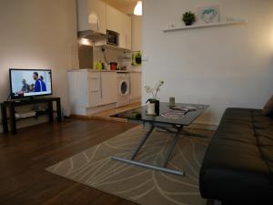 a living room with a table and a couch and a kitchen at Appartement Université-Capitole in Toulouse