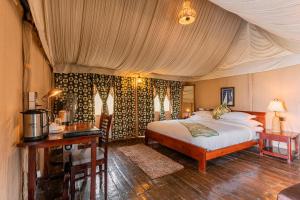 a bedroom with a bed and a desk in a room at Seed At Queens Meadows, Ranikhet in Rānīkhet