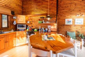 a wooden kitchen with a wooden table in a cabin at Under Milkwood Resort in Knysna