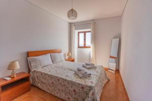 a bedroom with a bed with two towels on it at Emily's House in Arcos de Valdevez +16 photos