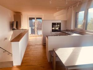 cocina grande con paredes blancas y suelo de madera en Obstbau Apartment am See en Lindau