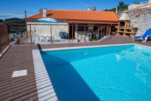 a swimming pool in front of a house at Emily's House in Arcos de Valdevez
