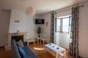 a living room with a couch and a fireplace at Emily's House in Arcos de Valdevez