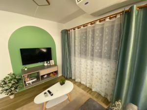 a living room with a white table and a tv at PTJ Style Condotel คอนโดเมืองทอง P2 in Nonthaburi