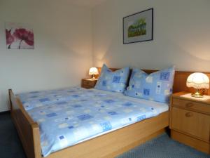 a bedroom with a large bed with blue pillows at Haus Schönblick in Strobl