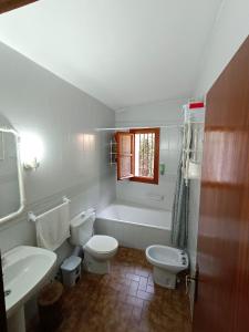 a bathroom with two toilets and a tub and a sink at Casa Rural La Argentina in Bubión