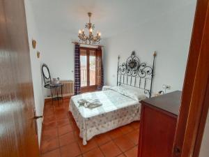 a bedroom with a bed and a table and a chandelier at Casa Rural La Argentina in Bubión