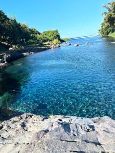 聖貝努瓦的住宿－CAPLINE，一条有蓝色水源、岩石和树木的河流