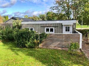 una casa pequeña con porche y escaleras en Fint sjönära annex en Växjö