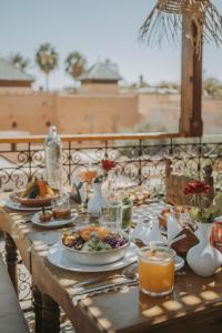 a wooden table with plates of food and drinks on it at Riad Casa Kasbah in Marrakech