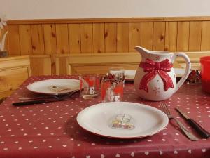 uma mesa com uma toalha de mesa vermelha com um prato e um vaso em La Piccola Baita di Filettino em Filettino