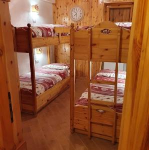 a room with two bunk beds and a clock on the wall at La Piccola Baita di Filettino in Filettino